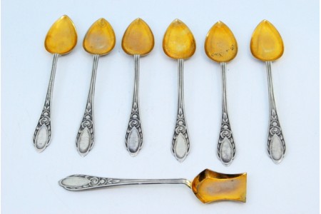 Conjunto de seis colheres de café e pá de açúcar em prata com conchas douradas e relevos florais.